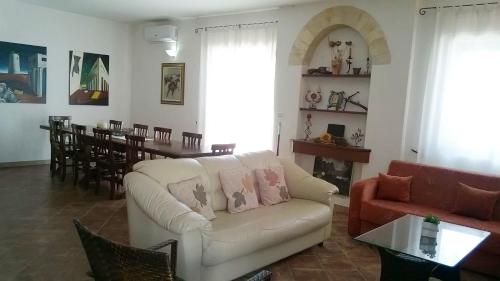 a living room with a white couch and a table at Casa Elda in Galatone
