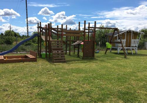 a park with a playground with a slide at Łebskie Chatki in Łeba