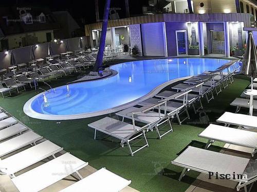 a large swimming pool with chairs and a bunch ofitures at Hotel Bellavista in Marina di Varcaturo