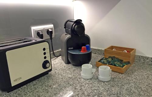 a kitchen with a toaster and cups on a counter at Cascais 4 You in Cascais
