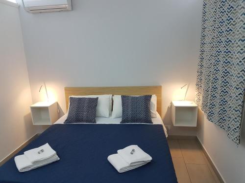 a bedroom with a bed with two towels on it at GiglioApartment Etna Mare in Aci Castello