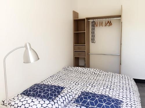 ボワ・コロンブにあるWest Paris Standard Flat with private gardenのベッドルーム1室(青い枕のベッド1台、冷蔵庫付)