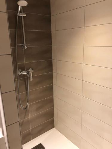 une douche avec une porte vitrée dans une salle de bain dans l'établissement ELANS, à Gérardmer