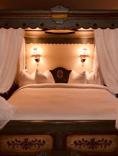 a bedroom with a bed with white sheets and lights at Enzian Inn in Leavenworth