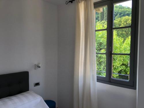 佩爾萊多的住宿－I Love Varenna，一间卧室设有一张床和一个大窗户