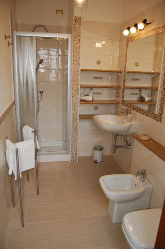 卡利亚里Manzoni Suite的带两个水槽、淋浴和马桶的浴室