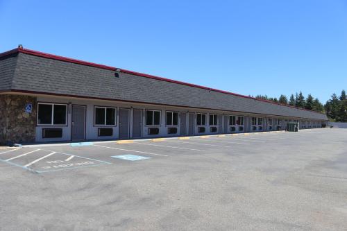 a large building with a lot of windows in a parking lot at Westward Inn in Crescent City