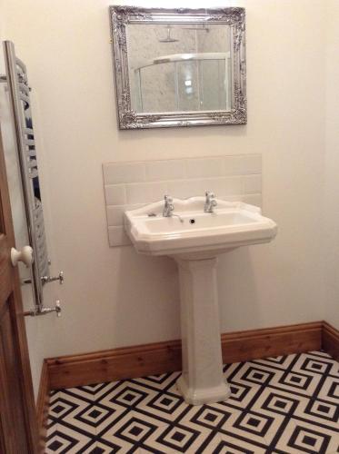 a bathroom with a white sink and a mirror at Treganoon House, Lanlivery in Bodmin