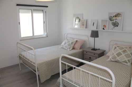 a bedroom with two beds and a window at Charming baixa in Lavradio