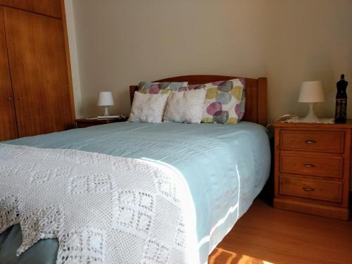 ein Schlafzimmer mit einem Bett und einer Holzkommode in der Unterkunft Casa do Pinheiro Manso in Valença