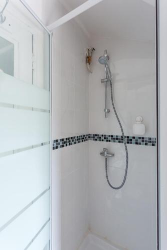 une douche avec pommeau de douche dans une salle de bain dans l'établissement Charming Studio - Palais de Congres, à Paris