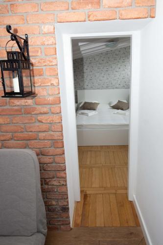a room with a brick wall and a bedroom with a bed at Saska Kępa Apartamenty in Warsaw