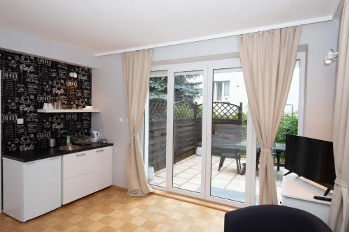 a kitchen with a sliding glass door leading to a patio at Saska Kępa Apartamenty in Warsaw