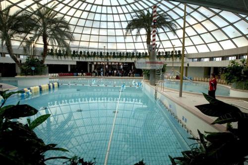 a large swimming pool with a glass domed ceiling at Beautiful penthouse near Rai and centre in Amsterdam