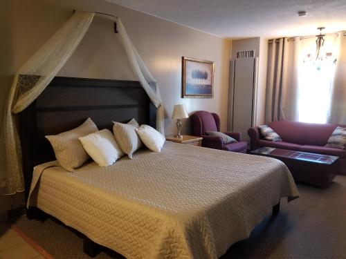 una camera con un grande letto e un divano di Knights Inn Woodstock a Woodstock