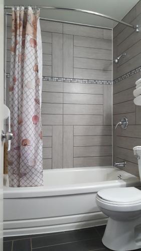 a bathroom with a bath tub and a toilet at Sunset motel in Portage La Prairie