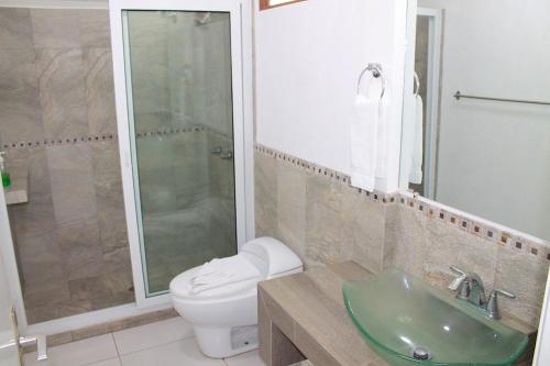 a bathroom with a toilet and a sink and a shower at Apartamentos Reforma in Guatemala