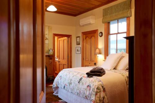 a bedroom with a bed and a large window at Maungakawa Villa in Cambridge