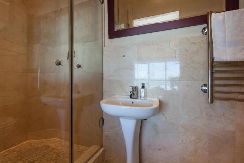 W łazience znajduje się umywalka i prysznic. w obiekcie Leisure Bay 306 by CTHA w Kapsztadzie