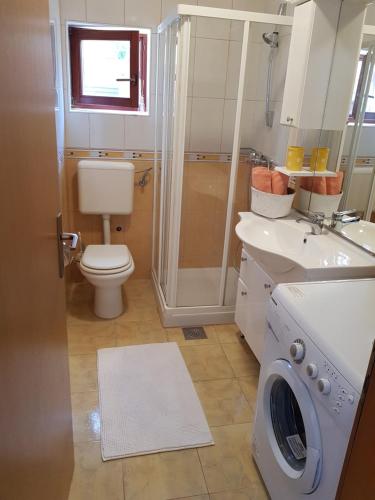 W łazience znajduje się umywalka i pralka. w obiekcie HOLIDAY HOME "MARIJANA" w mieście Ližnjan