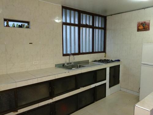 a kitchen with a sink and a stove in it at La Casa De Huespedes in Bogotá