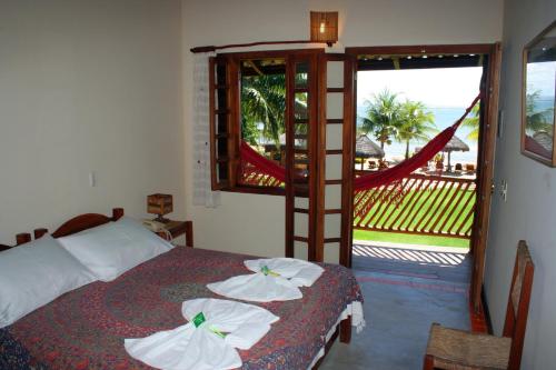1 dormitorio con 1 cama y balcón con vistas. en Pousada Ponta do Muta, en Barra Grande