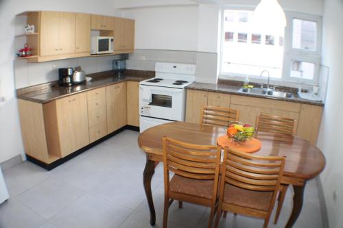 a kitchen with a wooden table and a table and chairs at Apartamentos Reforma in Guatemala