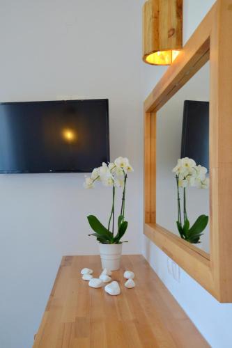 a table with a mirror and a vase with white flowers at Hawk Stone in Adamas