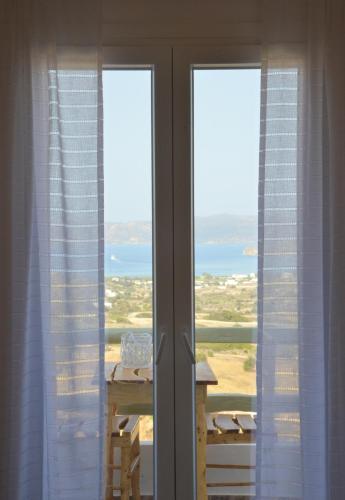 a room with two windows with a view of a table at Hawk Stone in Adamas