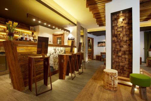 a restaurant with a bar with a bunch of chairs at Chalet Vites Mountain Hotel in Canazei