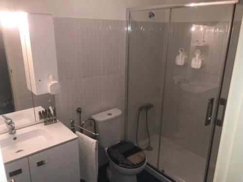 uma casa de banho com um chuveiro, um WC e um lavatório. em Gamboa Surf Apartment em Peniche