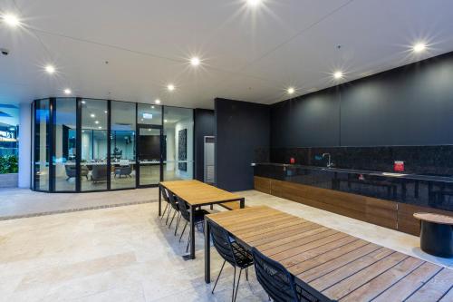 a restaurant with two wooden tables and a counter at Boardwalk Burleigh Beach - Official in Gold Coast