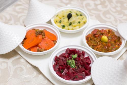 four bowls of different types of food on a table at Riad Dar Bab Guissa in Fès