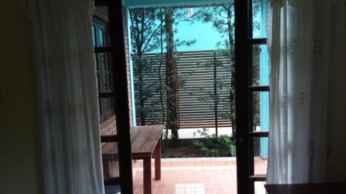 eine offene Tür zu einer Terrasse mit einer Holzbank in der Unterkunft Atlântico in Maresias