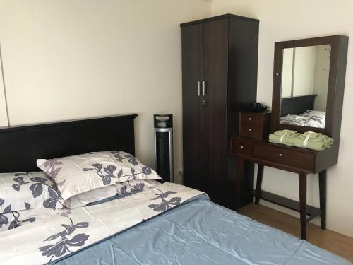 - une chambre avec un lit, une commode et un miroir dans l'établissement Cozy 922 at Tower One, à Cebu