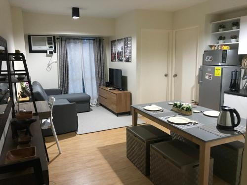 Il comprend un petit salon avec une table et une cuisine. dans l'établissement Cozy 922 at Tower One, à Cebu