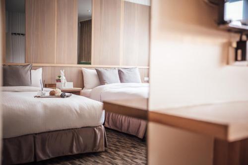 a hotel room with two beds and a table at Muzik Hotel - Ximending Xining Branch in Taipei