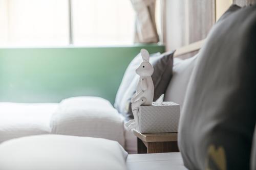 a room with a couch and a table with a toy rabbit in a box at Muzik Hotel - Ximending Xining Branch in Taipei