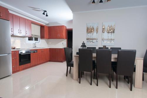 a kitchen with a wooden table and black chairs at A perfect summer destination next to the sea in Mikrá Mandínia