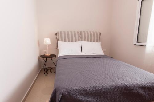 a small bedroom with a bed with a striped headboard at A perfect summer destination next to the sea in Mikrá Mandínia