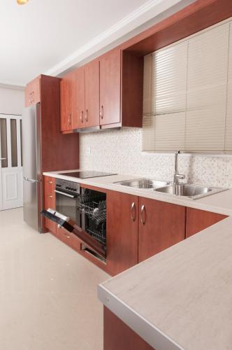 a kitchen with wooden cabinets and a sink at A perfect summer destination next to the sea in Mikrá Mandínia