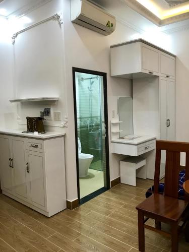 a kitchen with white cabinets and a glass door at Khanh Phong Apartment PG02-20 in Hai Phong
