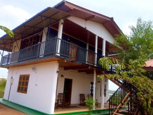 a large white house with a balcony on it at Sunntop Cabana in Trincomalee