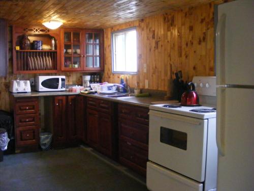 a kitchen with wooden cabinets and a white stove top oven at 78 Montague in Digby