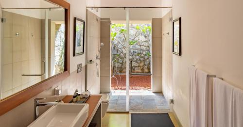 a bathroom with a sink and a mirror at Taru Villas The Long House - Bentota in Bentota