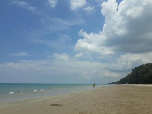 a person flying a kite on the beach at Mae Rampung Beach House คาราโอเกะและสระเด็ก in Rayong
