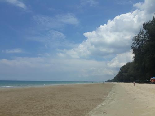 a beach with a person flying a kite on it at Mae Rampung Beach House คาราโอเกะและสระเด็ก in Rayong