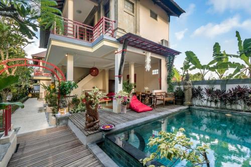 a house with a swimming pool in front of a house at Metteyya Healing House in Ubud