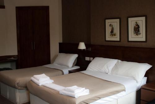 two beds in a hotel room with towels on them at Edinburgh House Hotel in Edinburgh