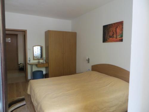 パンポロボにあるApartment "Moni"のベッドルーム1室(ベッド1台付)、木製キャビネットが備わります。